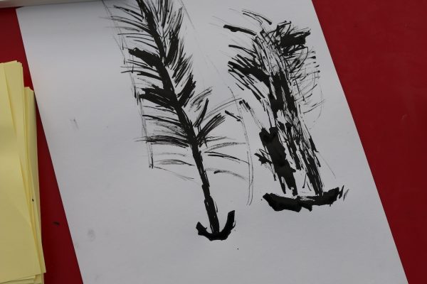 A child's ink drawing of a pine tree on a red Formica table